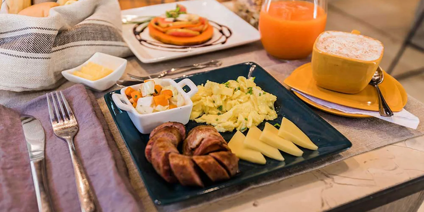 Residencia Santa Clara breakfast with eggs, fruit, cheese, bread, coffee, and fresh juice